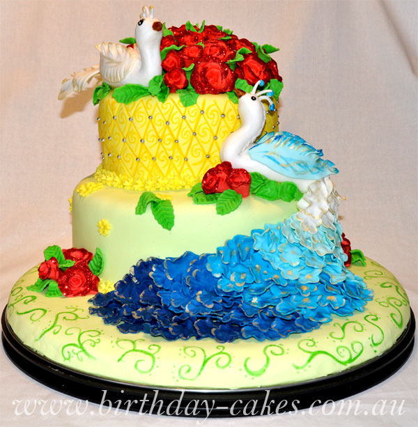 Colourful peacock birthday cake decorated with fondant roses